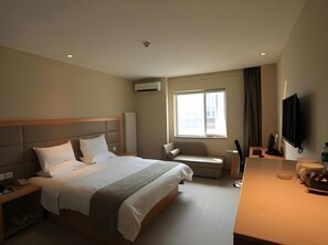 A hotel room with a large bed, a desk, a chair, a TV, and a window. - Ji Hotel (Beijing)