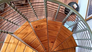 A spiral staircase with wooden steps and metal railings.