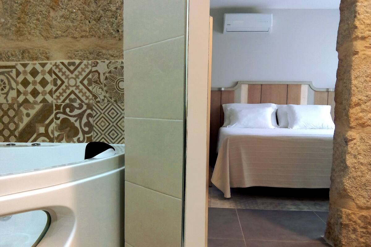 A bathroom with a bathtub, a shower, and a patterned wall.