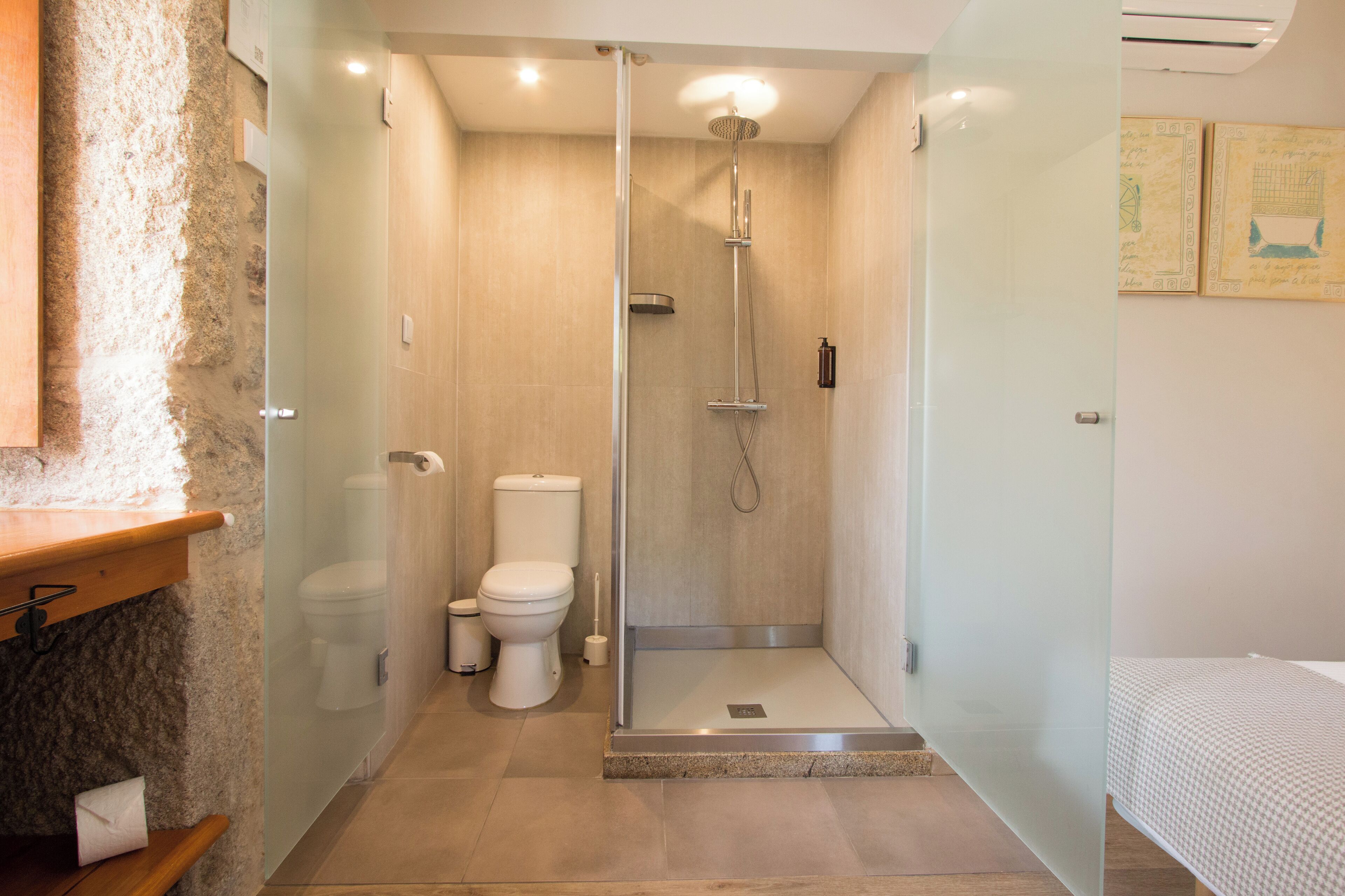 Un baño moderno con ducha envuelta en vidrio, inodoro y lavamanos.