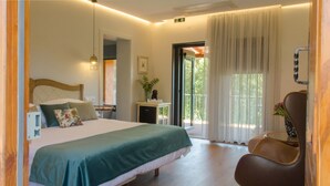 Habitación de hotel con cama, una silla, una mesita y vistas al exterior.