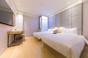 A hotel room with two beds, a desk, a chair, a TV, and a large window. - Ji Hotel (Hangzhou)