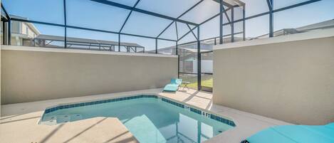An indoor swimming pool with a glass ceiling, a sunshade, and a lounge chair.