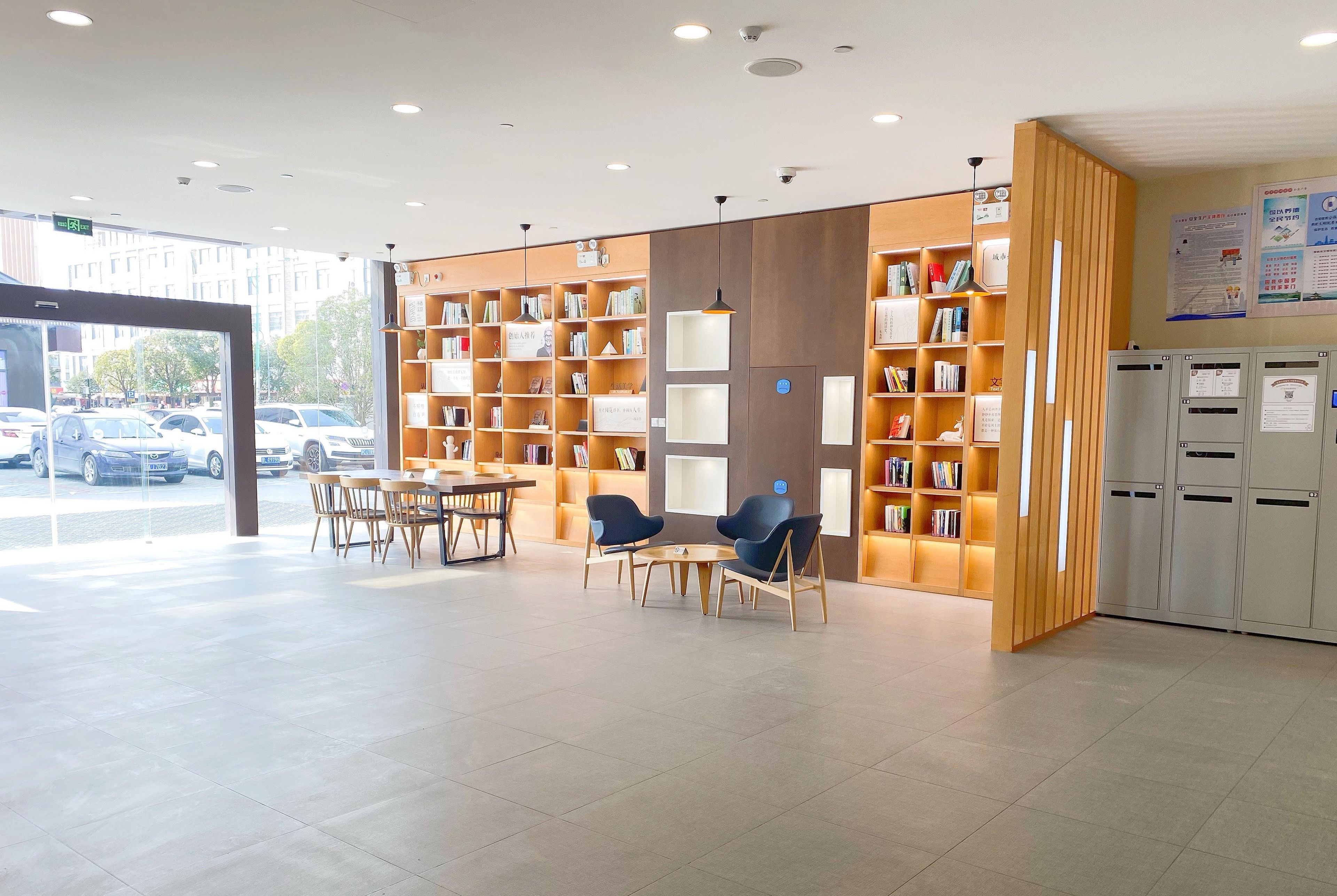Una biblioteca moderna con estanterías, zona de estar y taquillas.