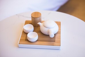 A white teapot, two white cups, and a wooden container on a white tray. - JI Hotel (Beijing)