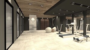 A modern gym with exercise equipment, a wooden floor, and glass walls. - Standing megeve - 2 to 8 people - Mont Arbois - ⛷️ and 🏌️‍♀️ (Megeve)