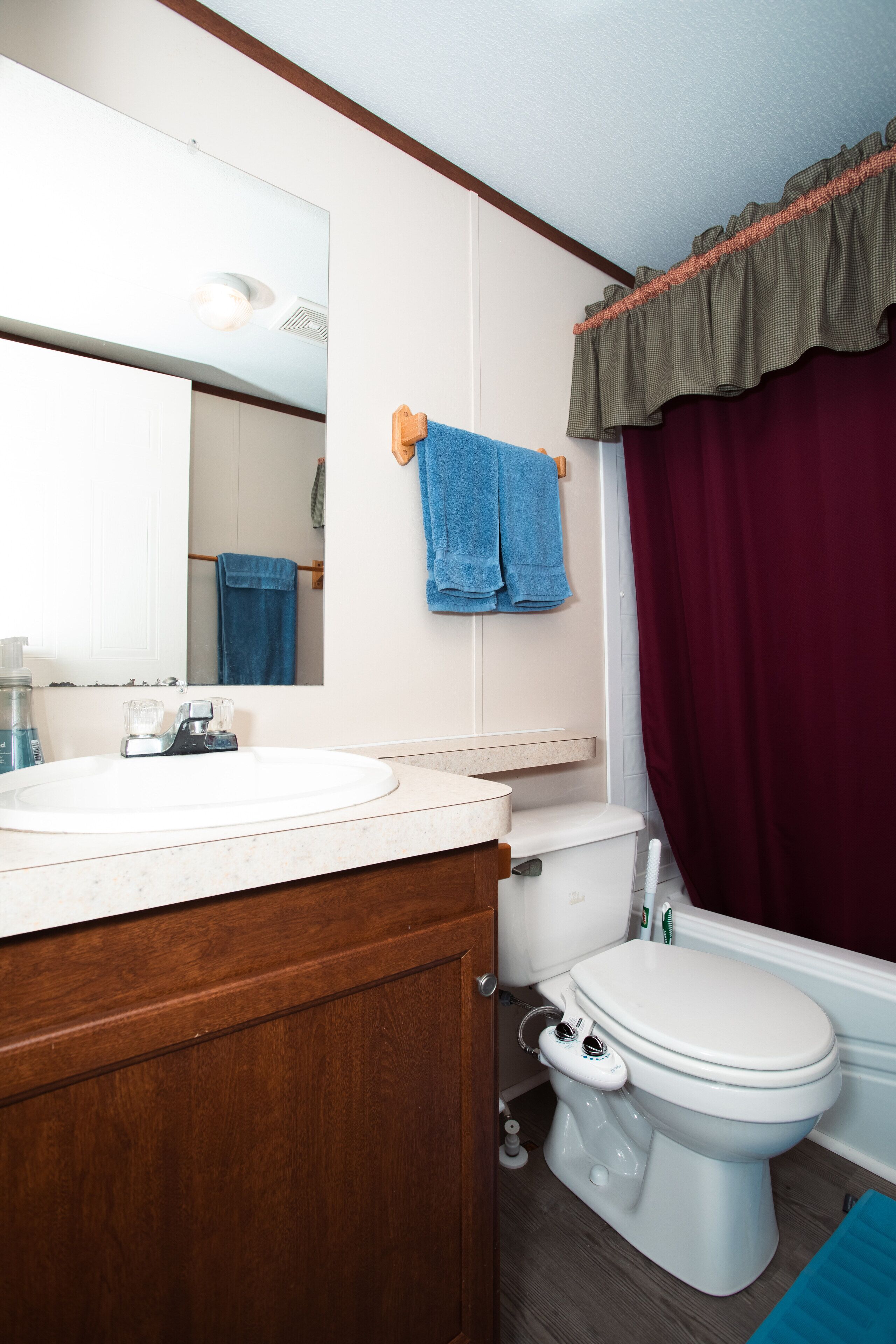 Une salle de bain avec un lavabo blanc, des toilettes et un miroir.