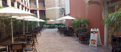 An outdoor patio area with tables and chairs, a Marketplace deli sign, and a sign for the Convention Center.