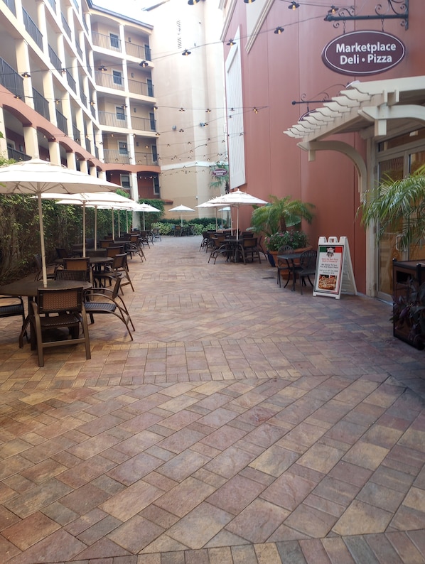 An outdoor patio area with tables and chairs, a Marketplace deli sign, and a sign for the Convention Center.