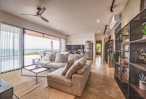 Relax in this stylish living room with a sofa, coffee table, and ocean views from the balcony.