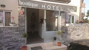 A boutique hotel with a stone facade, a reception desk, and potted plants. - Hotel Boutique Natka (Rovinj)