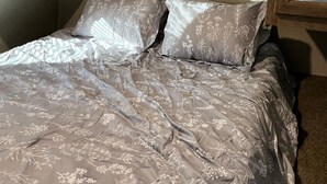 A bed with a floral-patterned bedspread and two pillows, a wooden headboard, and a mirror on the wall. - New updated, larger 1BR trailer, minutes from WEC and HITS, peaceful setting;  (Morriston)