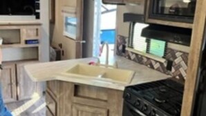 A compact RV kitchen with a stove, microwave, and sink. - New updated, larger 1BR trailer, minutes from WEC and HITS, peaceful setting;  (Morriston)