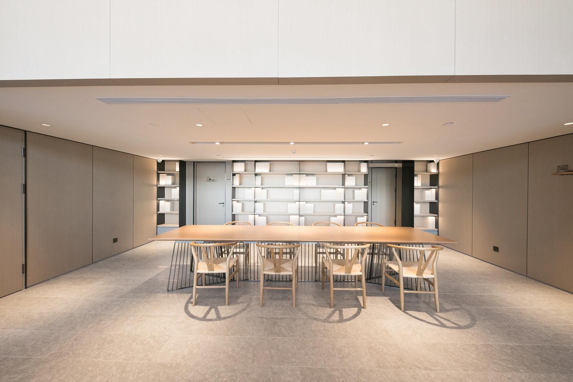 A conference room with a long table and six chairs, surrounded by bookshelves.