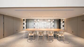 A conference room with a long table and six chairs, surrounded by bookshelves.