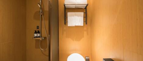 Un baño con ducha, inodoro y perchero para toallas.