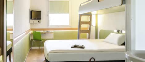 Una habitación de hotel con una cama litera, un escritorio con silla, un televisor y una ventana.