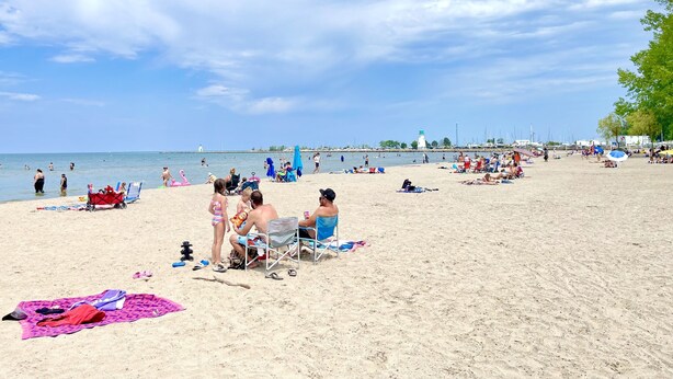 A beach with people sunbathing, swimming, and walking. - Fall Special: Stay Longer & Save Up to 40% in Niagara! (St. Catharines)