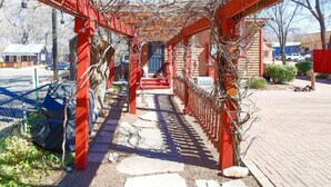 Una galleria coperta con ringhiere rosse e un vialetto in pietra.