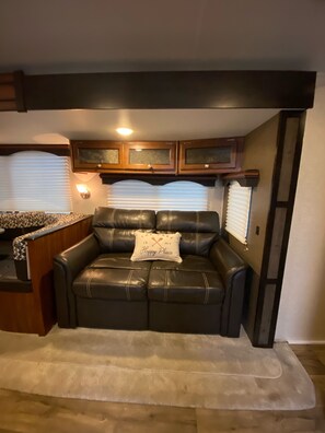 Relax in this cozy living area with a comfortable couch and ample storage.