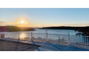 Stroll along the waterfront promenade with a serene view of the body of water and distant shoreline.