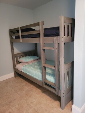 Un lit superposé à deux niveaux, chaque niveau étant équipé d’un matelas et d’oreillers.