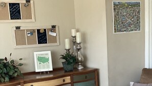 Ein Schlafzimmer mit einem Holztisch, einem Bett mit weißem Kopfteil und einer Karte an der Wand.
