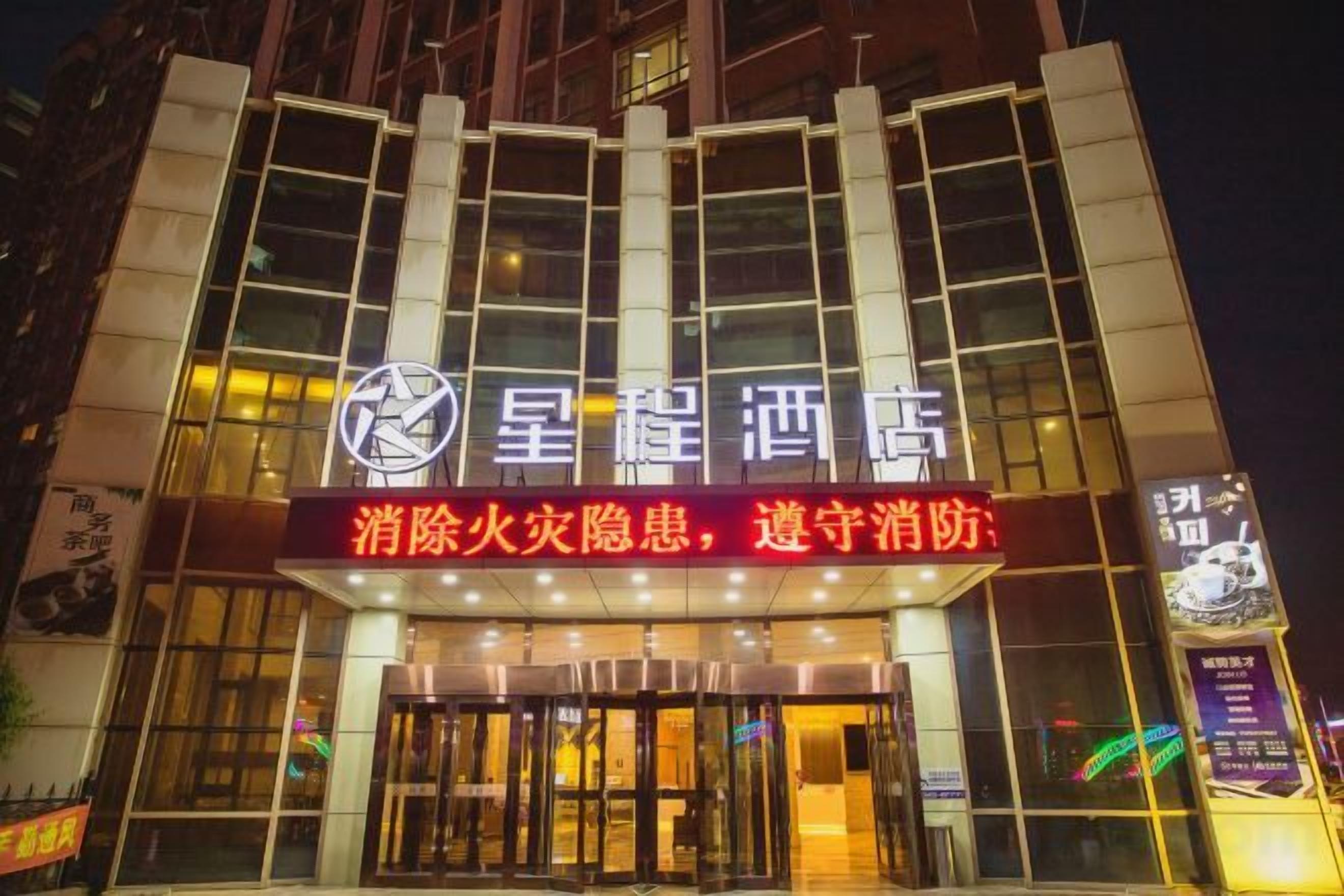 A hotel with a prominent sign and illuminated entrance.