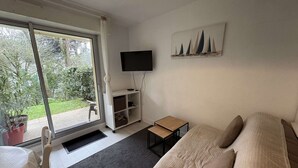 Makuuhuoneessa on sänky, televisio, pieni pöytä ja ikkunasta avautuu näkymä ulos.