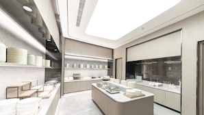 Una cocina moderna con una isla central, estantes empotrados y un amplio ventanal.