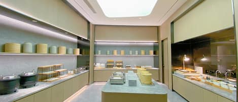 A modern kitchen with a central island, shelves with containers, and a skylight.
