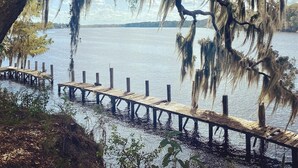 A wooden pier extending into a calm body of water, surrounded by trees with Spanish moss. - Relax by the River - Shell Harbour Room 4 on the St Johns River (Satsuma)