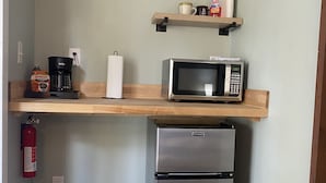 A compact kitchen with a microwave, coffee maker, and a stainless steel refrigerator. - Relax by the River - Shell Harbour Room 4 on the St Johns River (Satsuma)