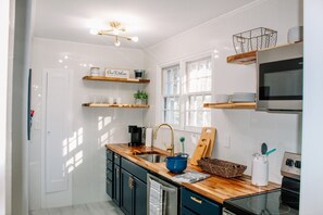 A modern kitchen with wooden countertops, a stainless steel sink, and a built-in oven.