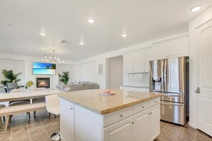 Enjoy cooking in this well-equipped kitchen with a central island, stainless steel appliances, and ample cabinetry.