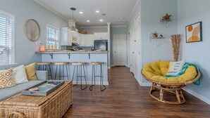 Une cuisine moderne avec des meubles blancs, un îlot central et des tabourets de bar.