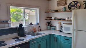 A kitchen with teal cabinets, a white refrigerator, a microwave, and a sink. - Beach vibes (Pointe-du-Chêne)