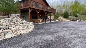 Une cabane en bois dotée d’un balcon, d’un mur en pierre et d’un drapeau américain.