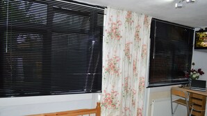 Une chambre à coucher avec un lit, un bureau avec un ordinateur portable et un radiateur.