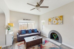 Cozy living space with a fireplace, sofa, and large window.