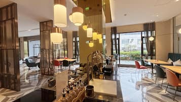 A modern hotel lobby with a bar area, seating arrangements, and large windows offering views.