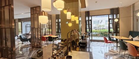 A modern hotel lobby with a bar area, seating arrangements, and large windows offering views.
