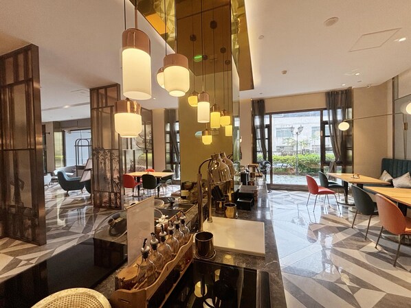 A modern hotel lobby with a bar area, seating arrangements, and large windows offering views. - Orange Hotel Donghui Citymall Zengcheng Guangzhou (Guangzhou)