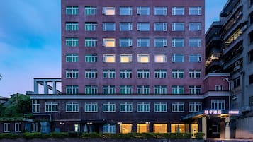 A multi-story hotel with a modern architectural design, featuring a prominent entrance with illuminated signage.