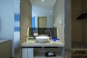 Casa de banho moderna com uma pia grande e branca, um espelho e um porta-toalhas.