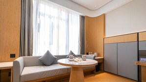 A modern room with a sofa, a round table, and a cabinet. - Ji Hotel Guanqian Street Chayuanchang Metrostation (Suzhou)