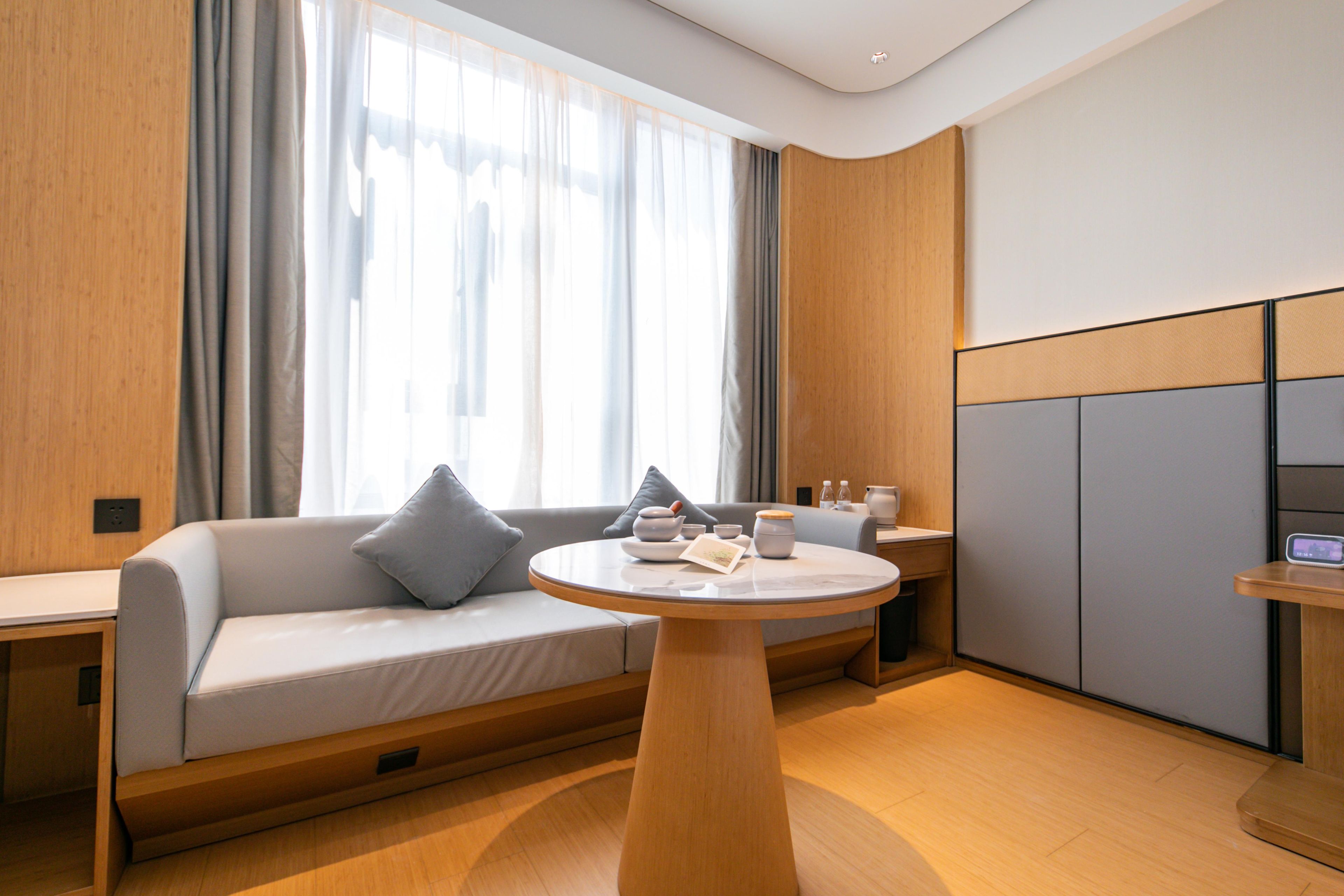 Quarto moderno com sofá, mesa redonda e armário.