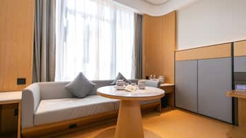 Quarto moderno com sofá, mesa redonda e armário.