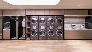 A modern laundry facility with multiple washing machines, a drying machine, and a sink area. - Ji Hotel Guanqian Street Chayuanchang Metrostation (Suzhou)