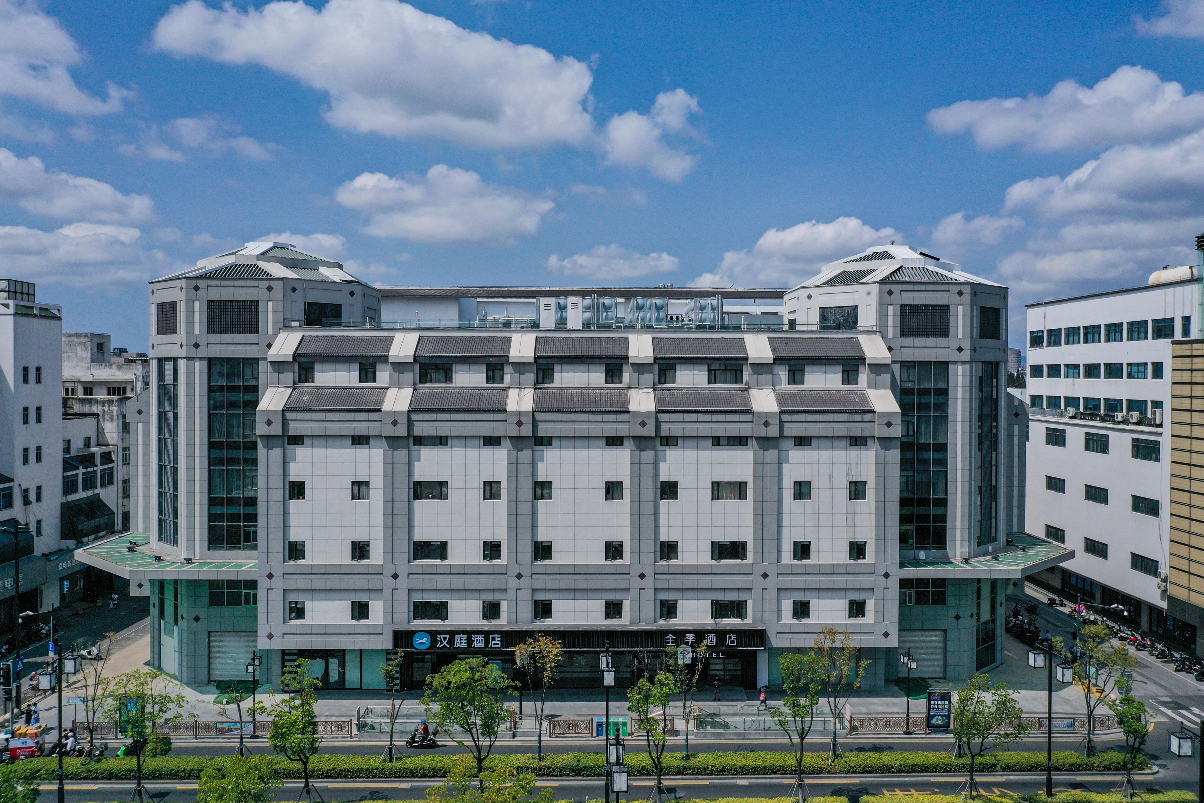 Ein modernes Hotel mit einer symmetrischen Fassade, großen Fenstern und einem markanten Eingang.